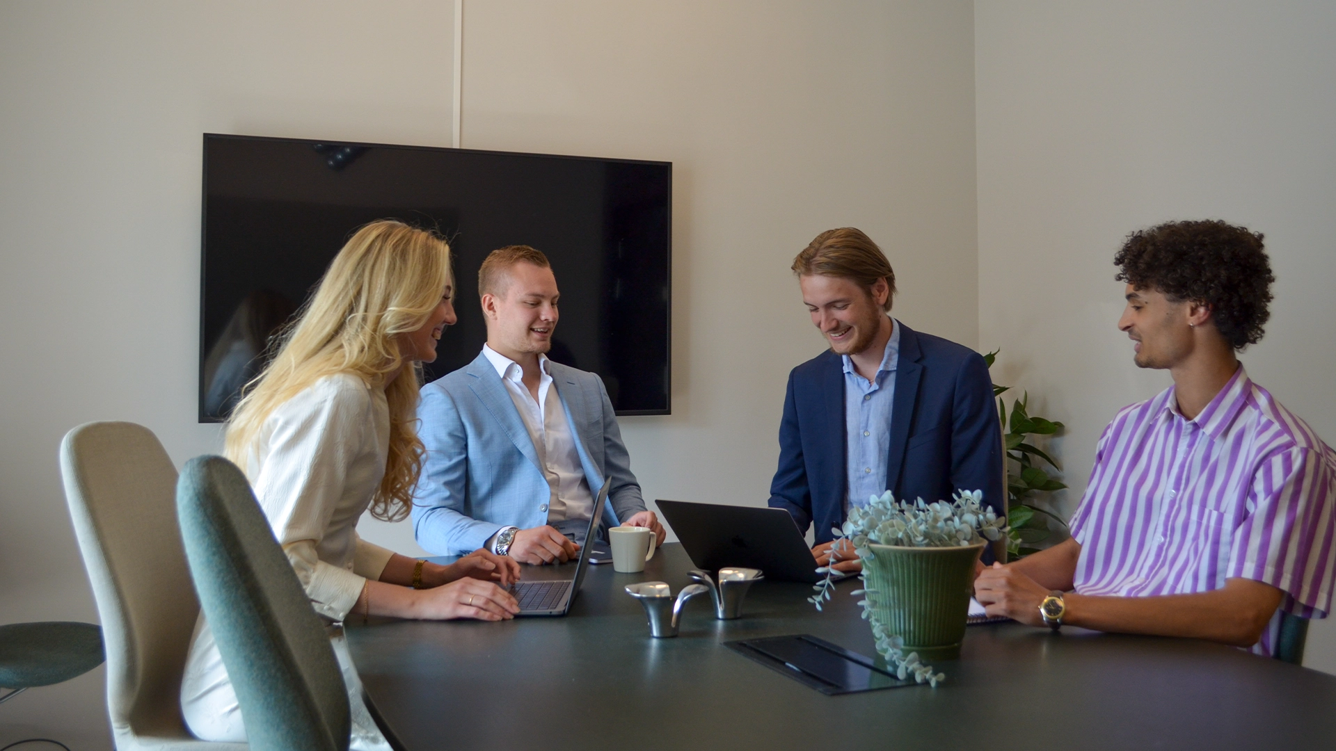 Kollegor på Internetbroker samlade runt ett konferensbord.